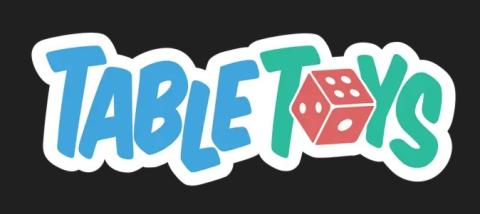 TABLE Großbuchstaben blau, TYS Großbuchstaben grün, Buchstaben nicht auf gerader Linie, O in Toys Würfel, rot, Kanten + Werte 1,2 und 4 in weiß sichtbar, alles auf Weiß, den Buchstabenumrissen folgend