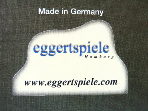 unregelmäßiger Fleck mit gerader Basis, darin "eggertspiele Hamburg" und "www.eggertspiele.de"